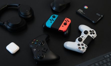 Mandos de videojuegos y auriculares sobre una mesa oscura